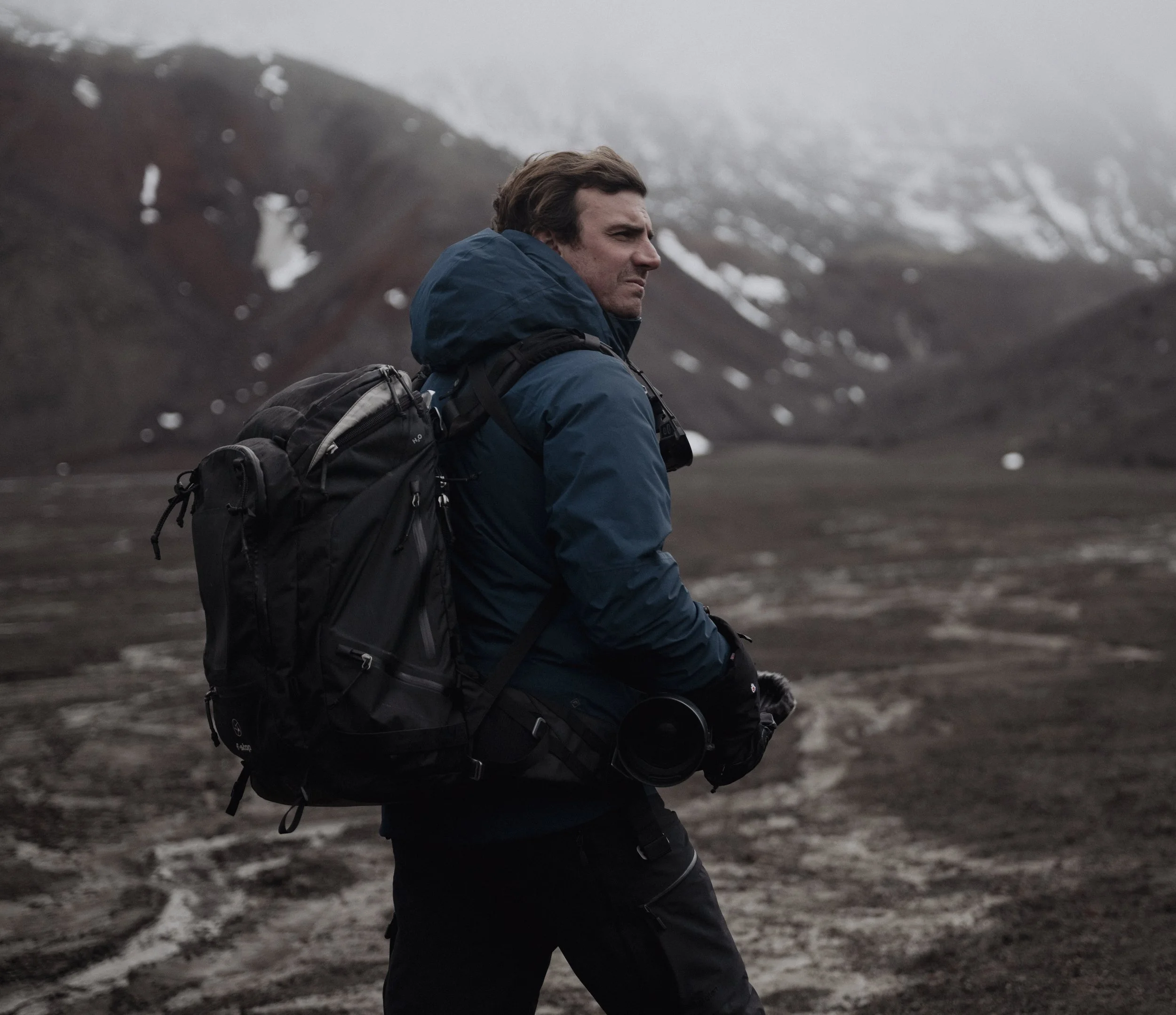 Niccol&ograve; Banfi with camera equipment trekking through remote mountains